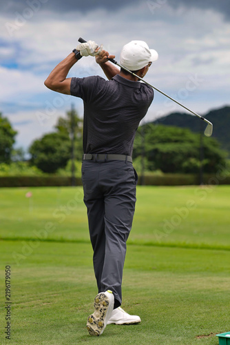 Asian golfer putting on a golf course.