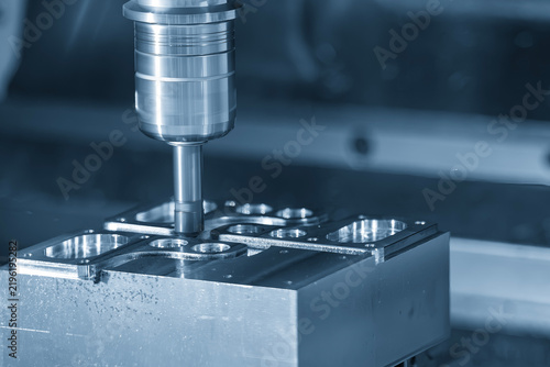 Parts deburring process on a CNC milling machine using a chamfer tool in a blue tone scene