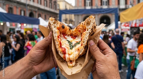 Person holding folded Neapolitan pizza in brown paper at street food festival. Traditional Italian pizza a portafoglio in Naples