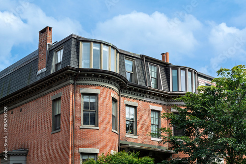 Decorative brick facade with bay windows and mansard roof in Boston, Massachusetts