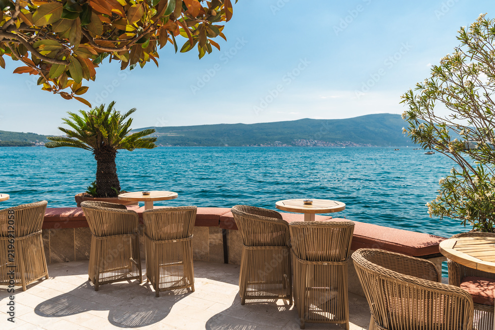 Obraz premium Sunny Waterfront Cafe Terrace Overlooking Mountain Coast in Tivat