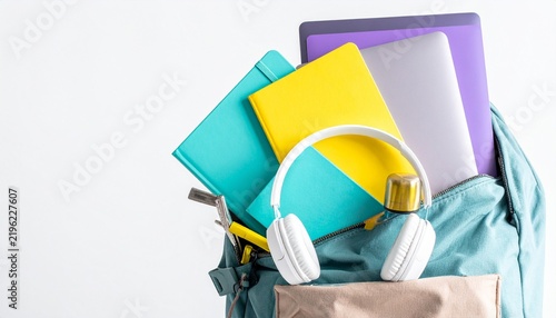 A mint green backpack filled with colorful notebooks, stationery, and a water bottle on a white background.