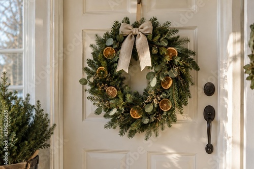 Evergreen wreath with dried oranges on a plain door