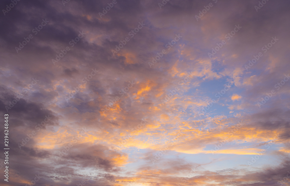 Fototapeta premium Vibrant Sunset Sky Panorama with Colorful Orange Pink and Blue Clouds,A panoramic photograph capturing a vibrant sunset sky filled with wispy cirrus clouds illuminated in golden yellow, orange, pink, 