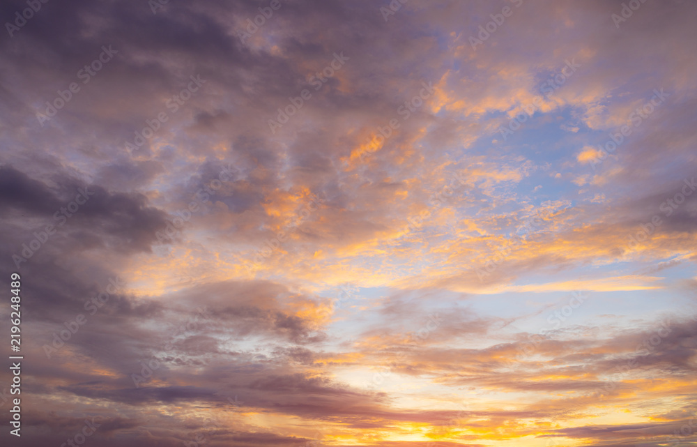 Fototapeta premium Vibrant Sunset Sky Panorama with Colorful Orange Pink and Blue Clouds,A panoramic photograph capturing a vibrant sunset sky filled with wispy cirrus clouds illuminated in golden yellow, orange, pink, 