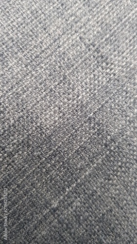 Close-up texture of grey woven fabric material with fine thread details.