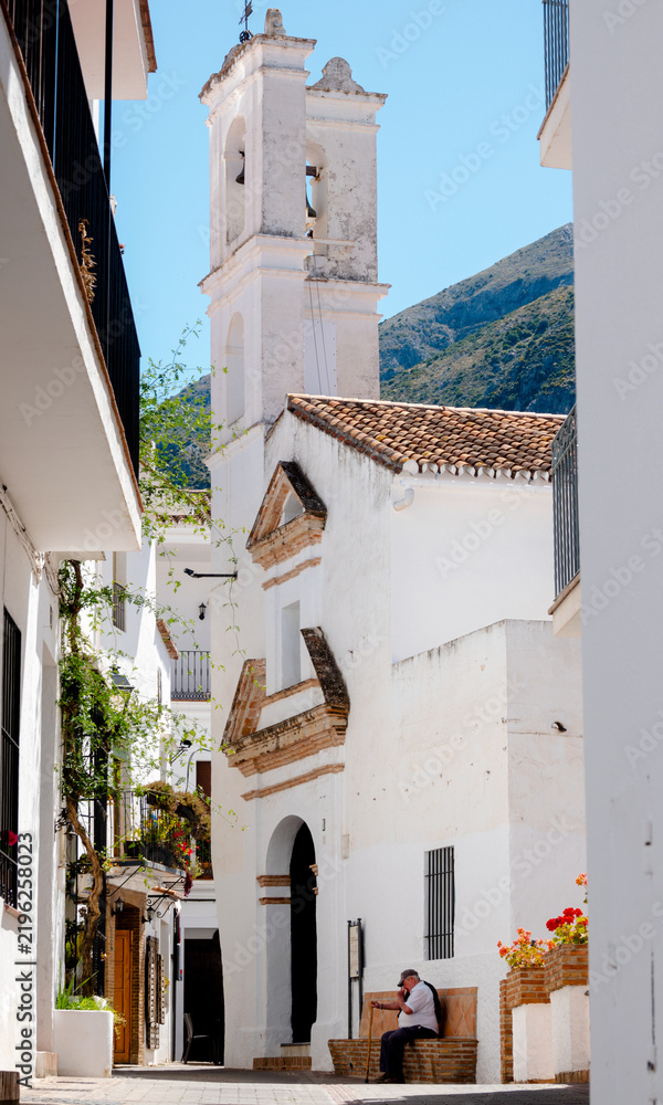 Obraz premium San Miguel Church and whitewashed street in Istán, Málaga, Spain