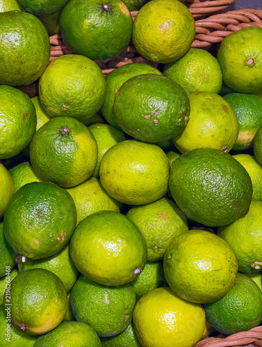 Yellow green limes arranged for sale at a supermarket produce display, showing fresh citrus fruits offered to customers at a grocery store