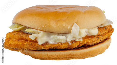 Crispy breaded chicken sandwich with pickles shredded lettuce and creamy sauce on a soft toasted bun. Golden fried chicken sandwich. Classic fast food meal with crunchy chicken and fresh toppings