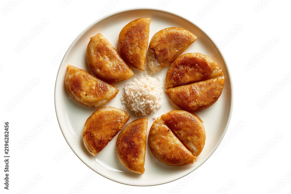 © Adrita - Top view of traditional Bengali taler pitha arranged on white plate with rice powder