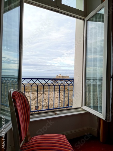 Foto Striped chair sits by an open window overlooking Fort National and the sea in Saint-Malo, Brittany, France, September 28, 2023