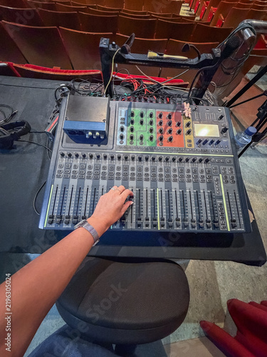 Sound engineer operating mixing console inside theater