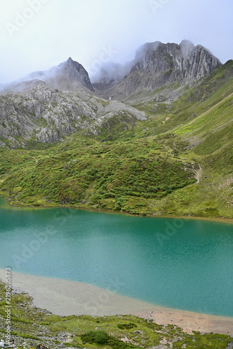 Turquoise Abujicuo Alpine Lake Surrounded by Rocky Peaks and Green Pastures in Shangri-La, Yunnan Province, China