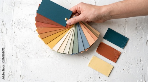 Hand holding colorful paint color swatches for design