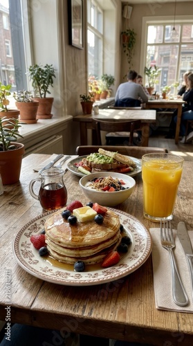 Delicious breakfast with pancakes orange juice and yogurt in a cafe