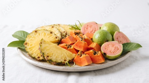 Tropical Fruit Platter: A vibrant arrangement of fresh, exotic fruits including sliced pineapple, papaya, and guava, artfully presented on a plate, inviting a taste of paradise.