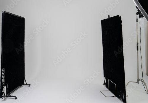Professional Photography Studio with Black Light Absorbing Panels and Lighting Equipment on Seamless White Background