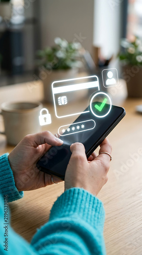 Secure mobile payment transaction showing credit card hologram and green checkmark icon on smartphone screen for safe digital banking and ecommerce checkout process in bright setting.