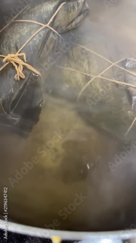 Hallacas boiling in pot close up bubbling water steam