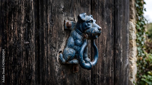 Rustic metal dog shaped door knocker on a weathered wooden door