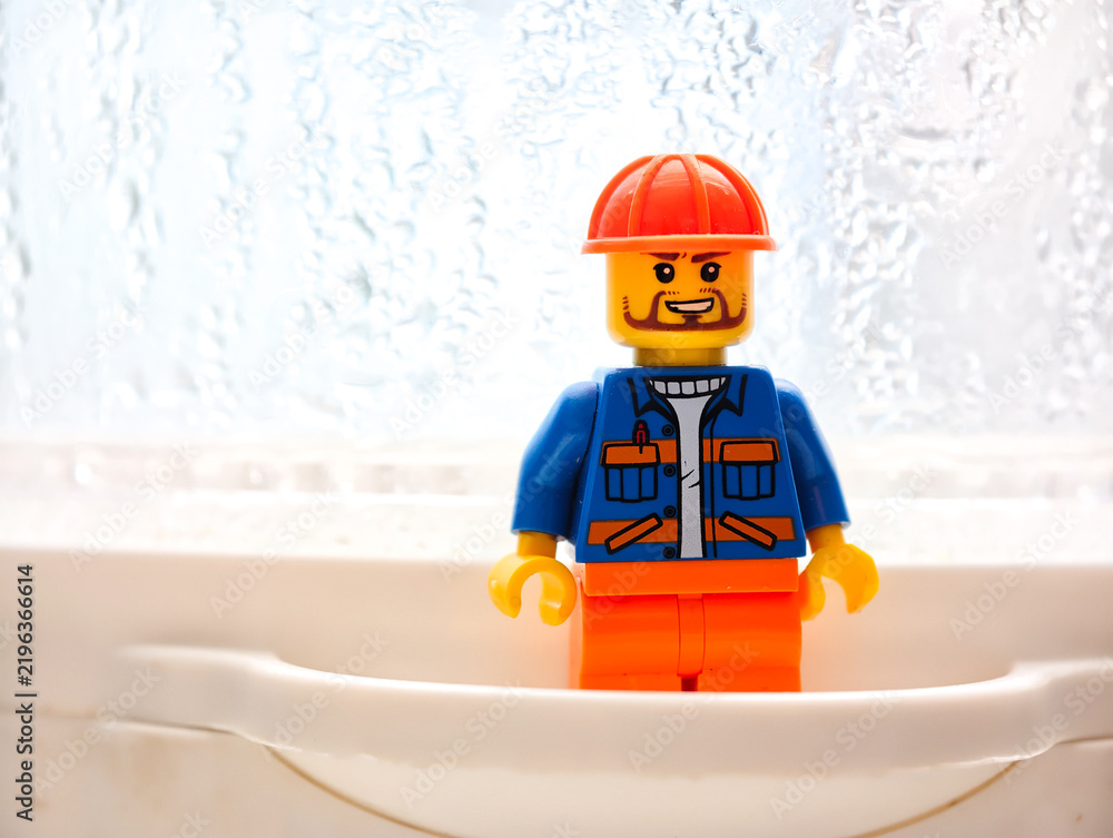 Fototapeta premium Russia, St. Petersburg, August 8, 2020 A miniature Lego man sitting in a bathroom sink, a creative and humorous scene