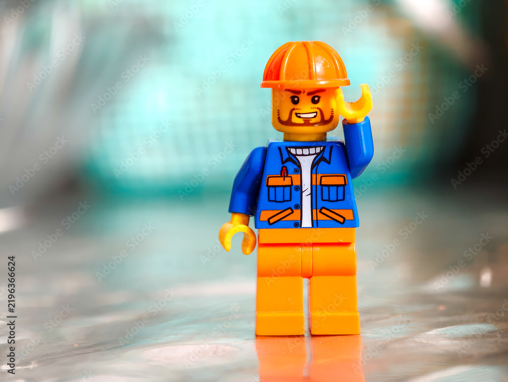 Fototapeta premium Russia, St. Petersburg, August 8, 2020 A detailed view of a Lego minifigure wearing a hard hat, great for construction or DIY projects