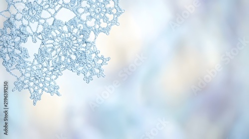 This captivating abstract image evokes the serene beauty of winter featuring a delicate snowflake pattern against a soft pastel colored blurred background creating
