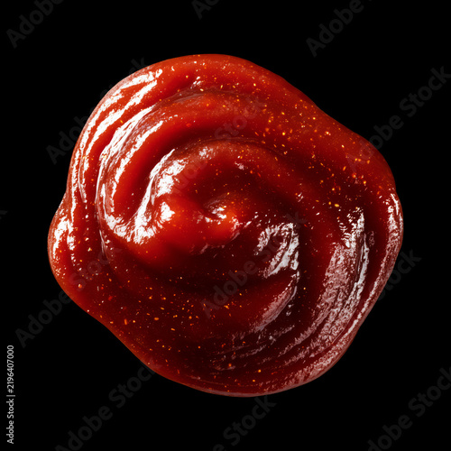 Closeup of glossy ketchup smear isolated on black background with clipping path, concept of condiments and cooking