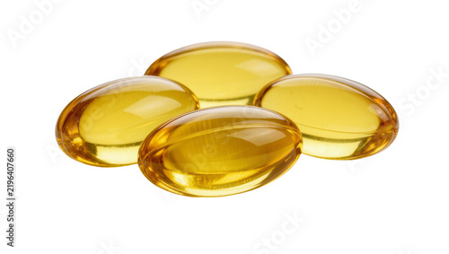 Four translucent golden oval softgel capsules, isolated on transparent background