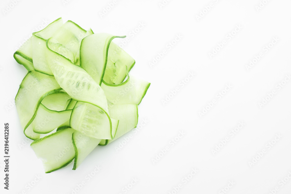 Obraz premium Slices of ripe cucumber on white background, top view. Space for text