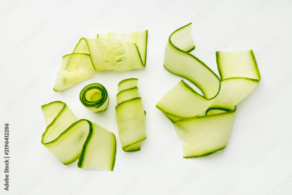Obraz premium Slices of ripe cucumber on white background, flat lay