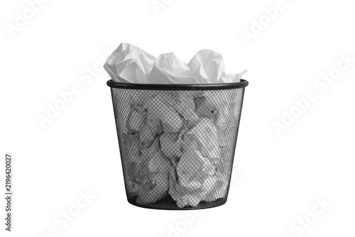 Black mesh trash bin filled with crumpled paper isolated