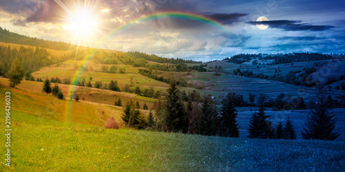 rural fields on autumn equinox. day meet night. sun and moon over trees on the grassy hills at twilight. beautiful countryside scenery of carpathian mountains. clouds on the epic sky