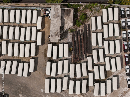 Aerial view of a large parking lot filled with rows of white buses and vans parked in an organized manner near Avenida Isabel Aguiar in Santo Domingo, Distrito Nacional, Dominican Republic.