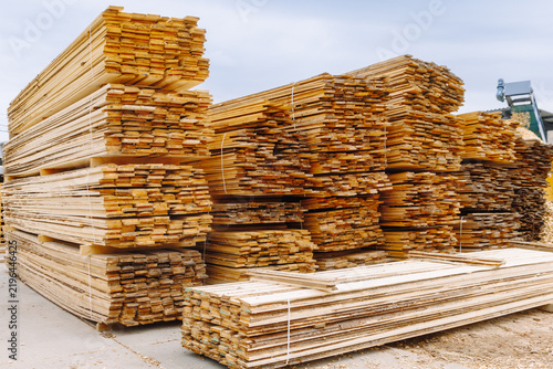 Stacks of neatly arranged wooden planks and boards in a lumber yard, showcasing various sizes and types of timber ready for construction projects