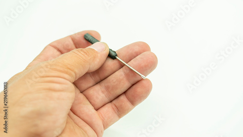 Konstfotografi A hand holds a small Phillips screwdriver designed for precision work, isolated against a white background