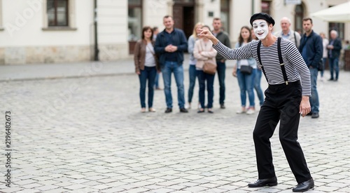 Mime artist performing on a European cobblestone street. Street performance art