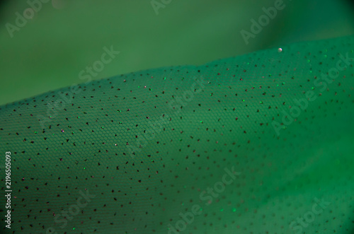 A delicate pastel background. A screen saver with fabric. A festive decoration. Light and bokeh. Green color. A greeting card for a wedding, engagement, or March 8. A template and copy space.