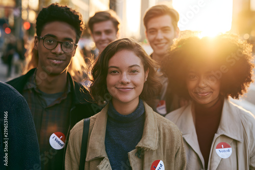 A diverse group of young voters proudly holding 