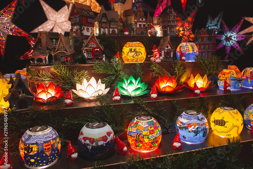 Colorful lit lotus flower lamps and decorative ceramic winter village models at a Christmas market