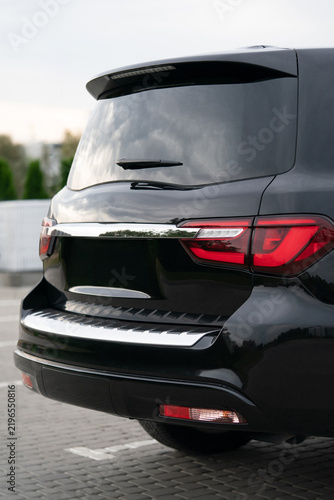 Rear view of a black luxury SUV with chrome trim and dark tinted windows