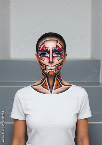 Model with creative artistic makeup posing on grey staircase