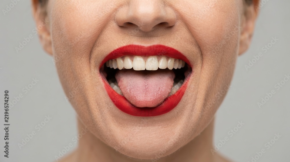 Fototapeta premium Close-up of a woman smiling with red lipstick and tongue out