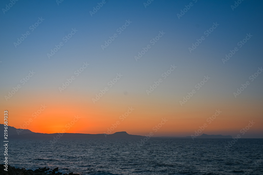 Fototapeta premium Golden Sunset Over the Sea and Mountains in Rethymno Crete
