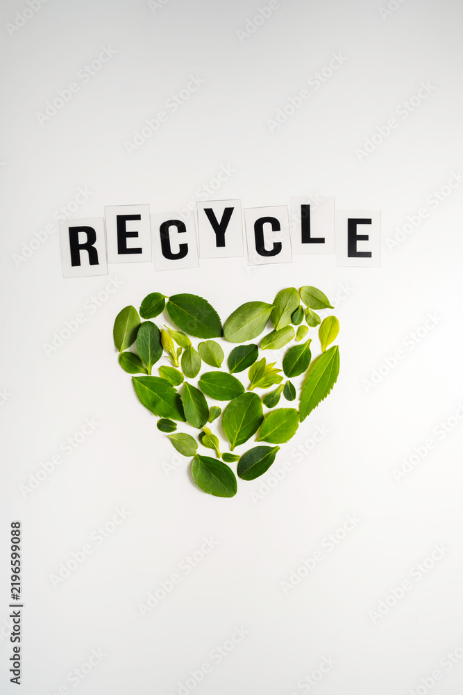 Obraz premium Recycle message with heart shape made of green leaves on white background, sustainability concept