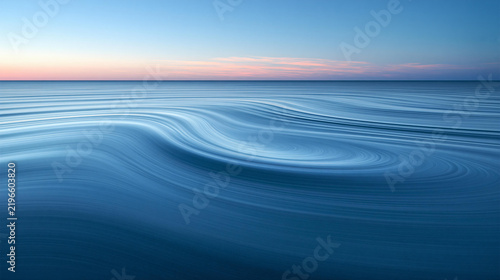 Calm Waves Reflecting Blue Hues Under a Serene Sky at Dusk Over the Ocean