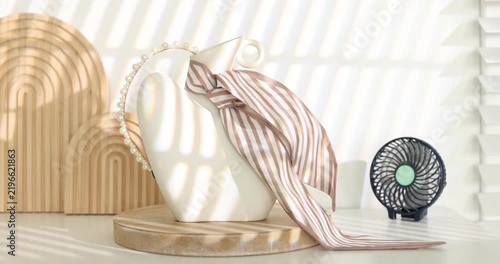 Mini fan and decorative vase with accessories on white table indoors