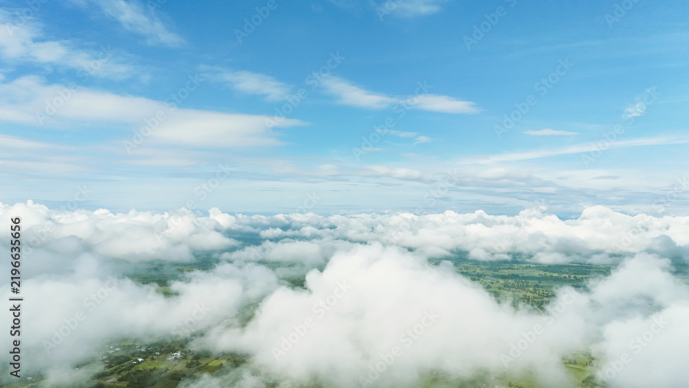 Fototapeta premium Above, vast clouds drift beneath clear blue sky