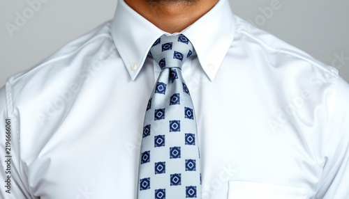 A person wearing a light blue patterned tie and a matching pocket square