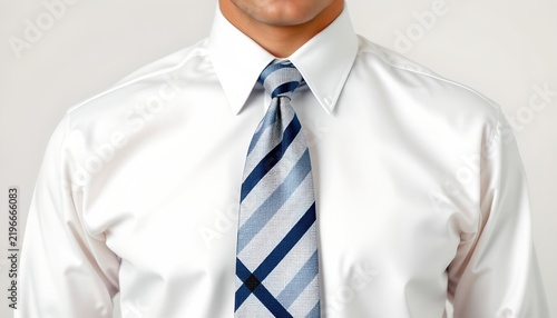 A man in a formal business attire. He is wearing a blue tie with a white pattern, complemented by a matching blue shirt and a dark colored necktie